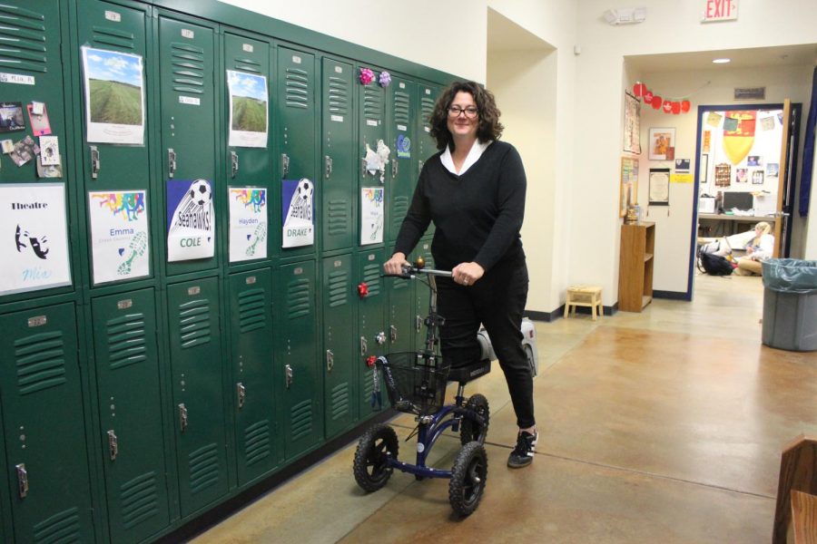 Faculty member Cris Bryan rolls down the hall with her new boot scooter. Bryan has had a boot since April 25th