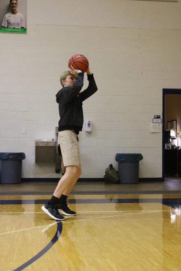 Freshman Shamus Sawyer prepares to shoot a basketball. Along with his love for all sports, he said he also has an interest in cars.