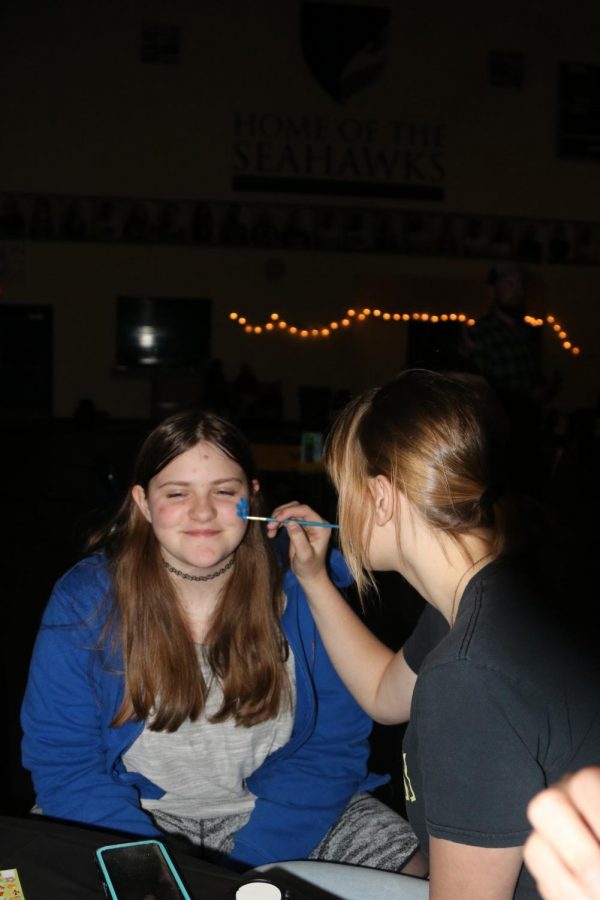 Alesia Brovtcnya paints Elizabeth Allen face during Carnival. Carnival this year was held in the gym.