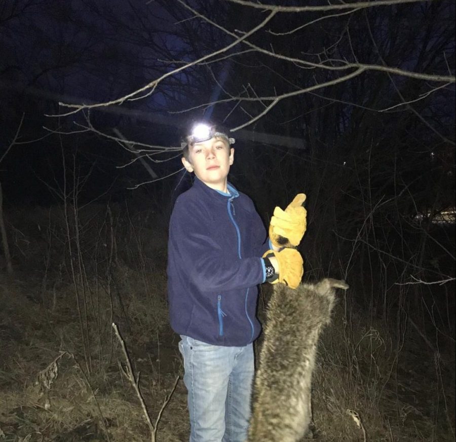 Hugh Griggs holds dead racoon. Griggs has recently taken over a bee colony as their lord and savior.
