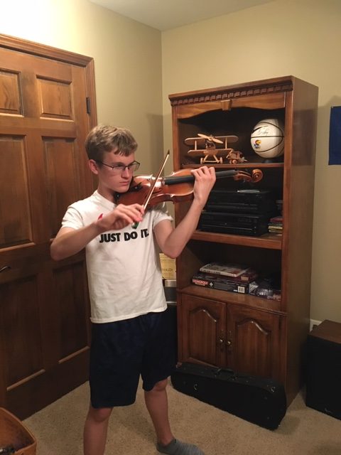 Freshman Noah Luke practice his violin. Luke has played violin for the Topeka Debut Youth Orchestra and the Philharmonic Orchestra of Kansas City