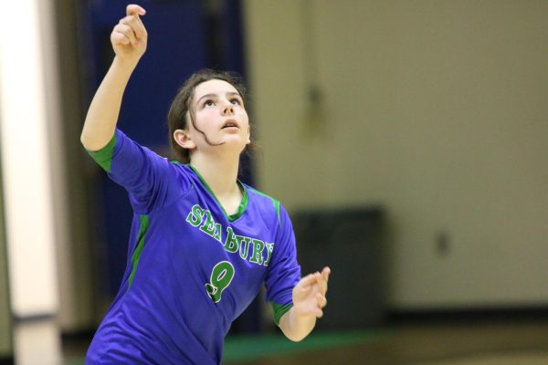 Sixth grader Alexandra Tsoflias focuses on her serve during a volleyball game. Her dad also played volleyball and inspired her interest in it.