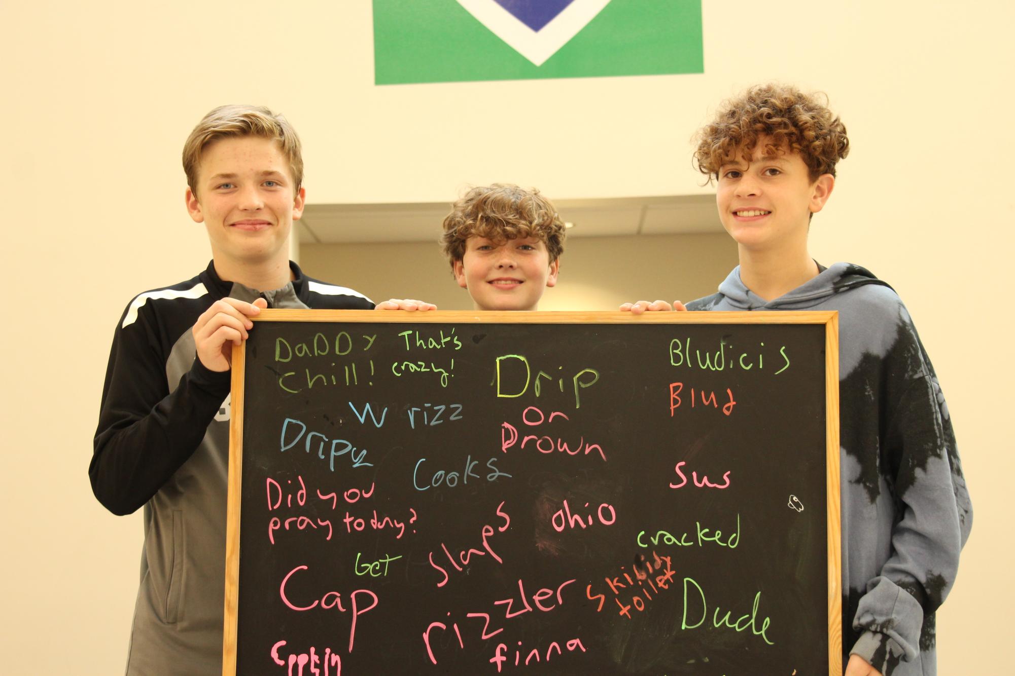  Eighth graders AJ Campbell and Kian Colistra and seventh grader Will Huerter pose with trending slang words. If you roam around the middle school hallways, you’re sure to encounter many of these. 