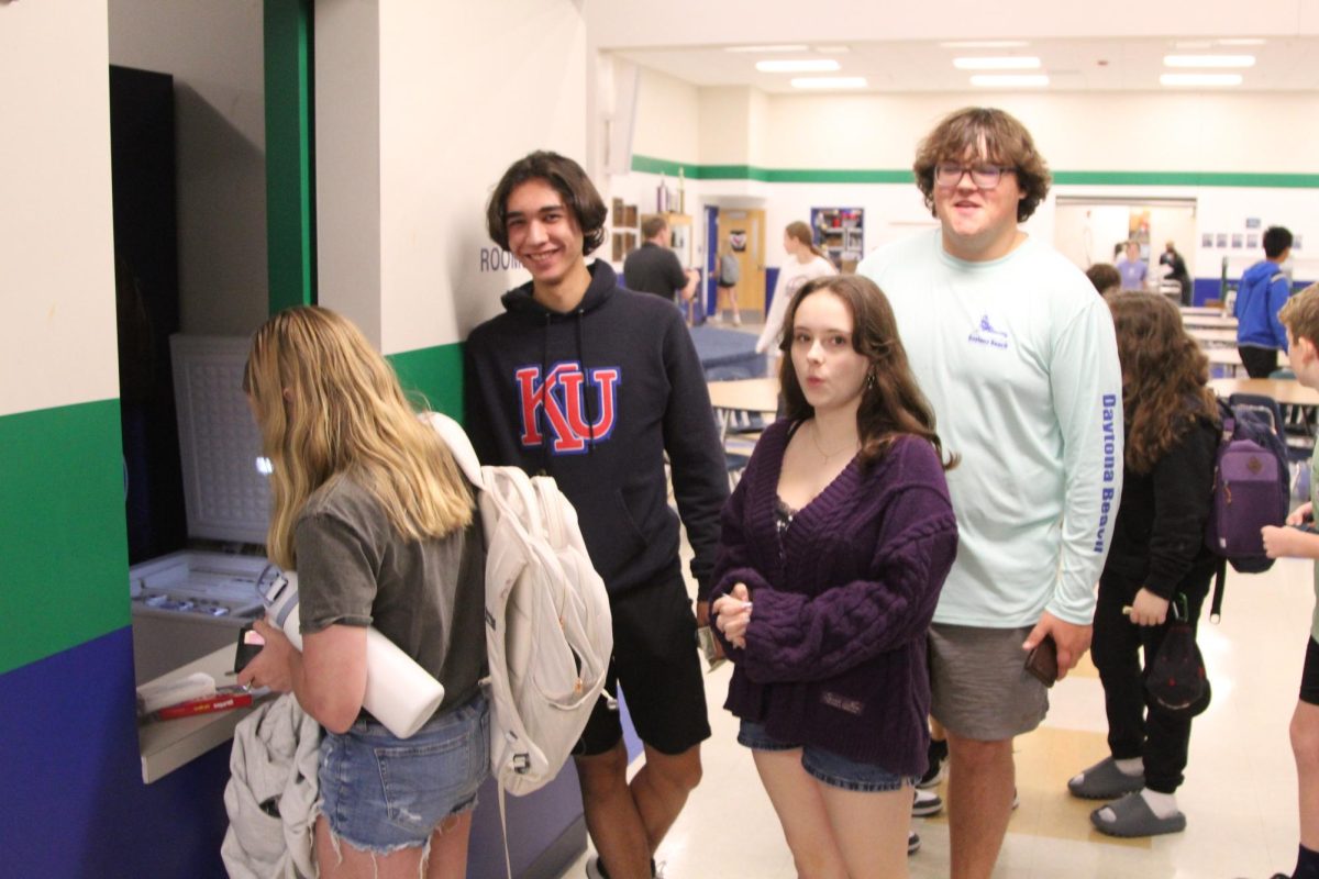 Sophomore Lillian Meier and juniors Riku Hickman and Max Fagan look on as sixth grader Megan Rinnert purchases a snack from the fabled Snack Shack.  This year, the Snack Shack has faced controversy about its prices and hours but has emerged as an increasingly successful business.