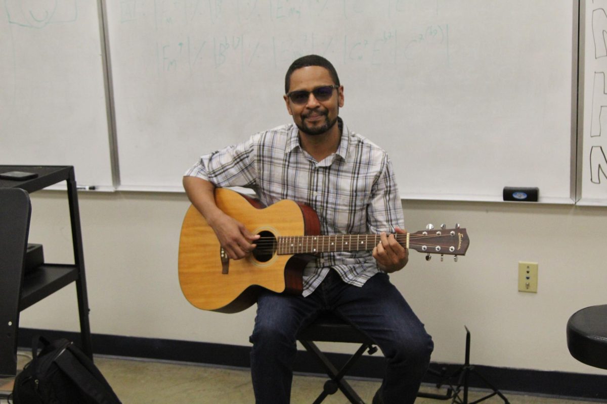 Instrumental Music teacher Michael Hamm plucks the strings of his acoustic guitar. Hamm’s musical abilities extend beyond just the guitar, however, as he also plays the electric bass and piano.