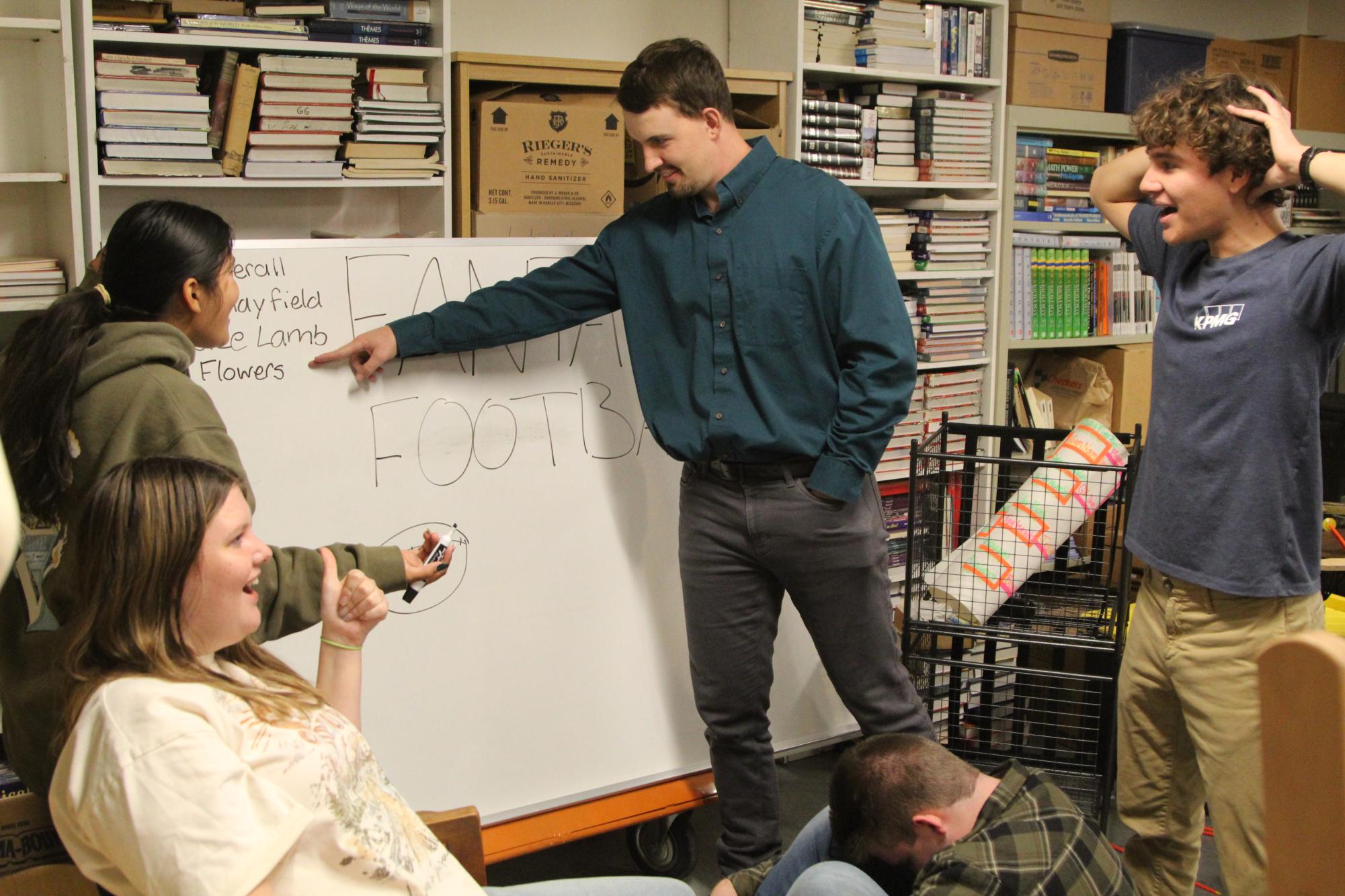 Math teacher Shane Richmond ferociously demands Zay Flowers as his team's Wide Receiver while senior Tara Thompson-Glodich angrily protests. Fellow senior Margaret Mulhern sits pleased in a chair as well as in 3rd place.